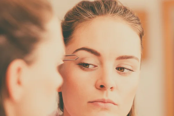 Woman plucking eyebrows — Stock Photo, Image
