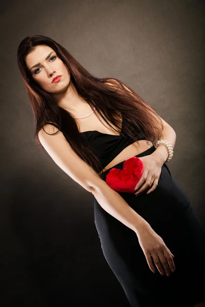 Beautiful woman holds red heart on black — Stock Photo, Image