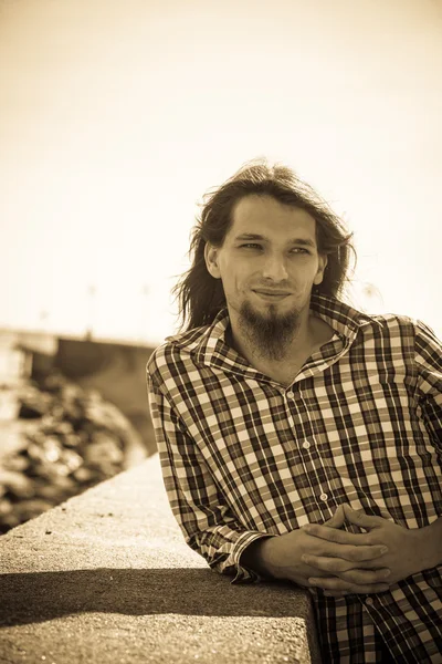 Homem longo cabelo relaxante à beira-mar — Fotografia de Stock