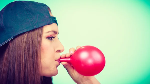 Menina soprando balão vermelho — Fotografia de Stock