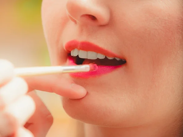 Maquillaje artista aplicando lápiz labial con pincel . — Foto de Stock