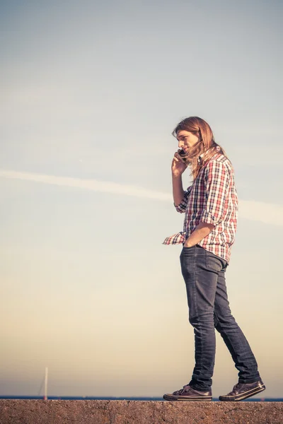 Man by seaside receiving a call on his phone — Stock Photo, Image