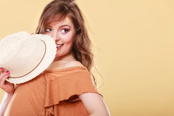 Cute girl holds summer straw hat covering her face — Stock Photo, Image