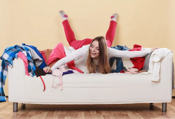 Mujer feliz recogiendo ropa en la habitación desordenada . —  Fotos de Stock