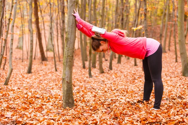 Meisje die zich uitstrekt in herfst park — Stockfoto