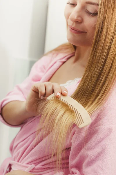 Mujer peinando el pelo en el baño . — Foto de Stock