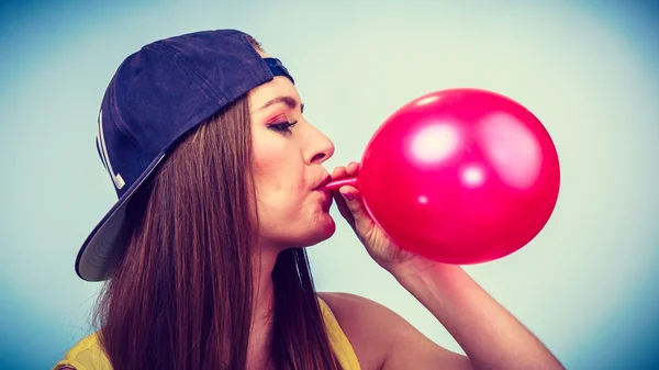 Chica soplando globo rojo . — Foto de Stock