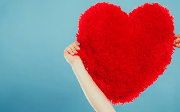 Almohada en forma de corazón en las manos. Amor de San Valentín —  Fotos de Stock