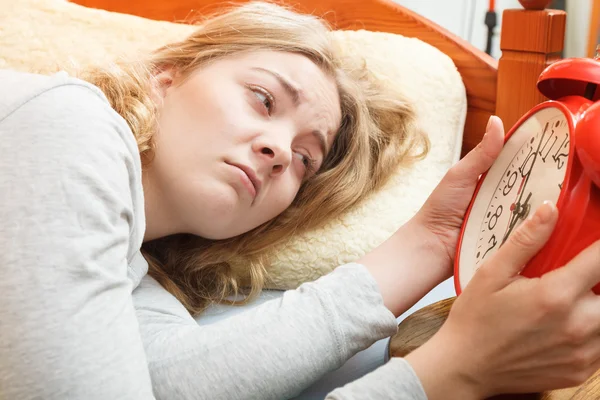 Woman waking up turning off alarm clock in morning — Stock Photo, Image