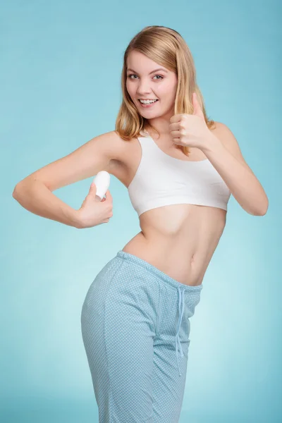Flicka tillämpa stick deodorant i armhålan. — Stockfoto