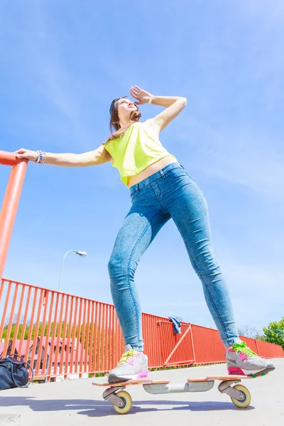 Dospívající dívka bruslař na koni skateboard na ulici. — Stock fotografie