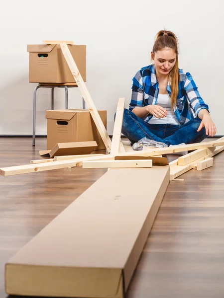 Woman moving into apartment assembly furniture. — Stock Photo, Image