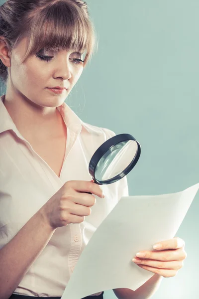 Woman uses magnifying glass to check contract — Stock Photo, Image