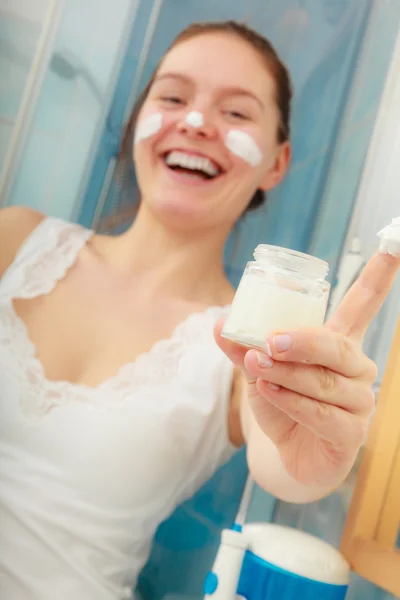 Mulher com creme de pele no rosto — Fotografia de Stock