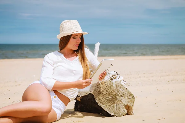 Kobieta za pomocą tabletki na plaży — Zdjęcie stockowe