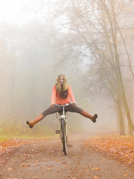 Mujer activa que se divierte montando bicicleta en el parque de otoño —  Fotos de Stock