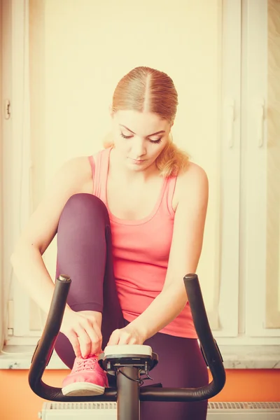 Kobieta na rower treningowy, sznurowanie butów — Zdjęcie stockowe