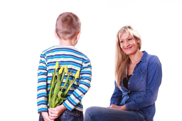 Niño pequeño con madre sostener flores detrás de la espalda . —  Fotos de Stock