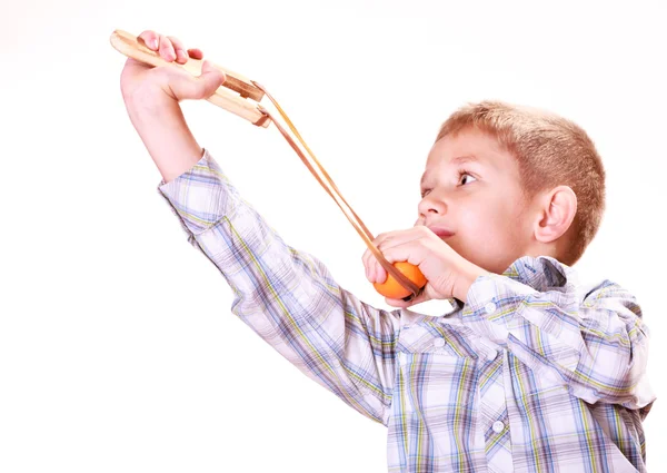 Jonge jongen gebruik sling shot schieten Mandarijn. — Stockfoto