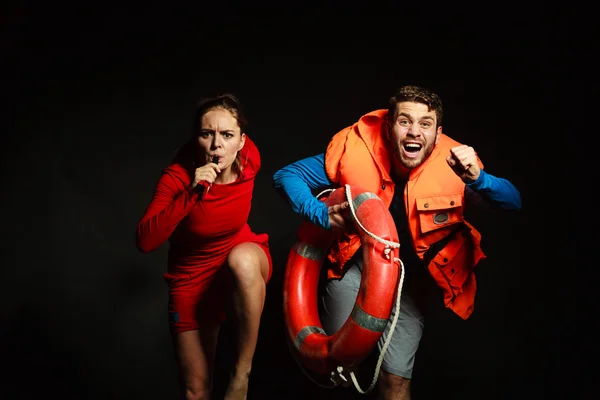 Lifeguards in life vest with ring buoy whistling. — Stock Photo, Image