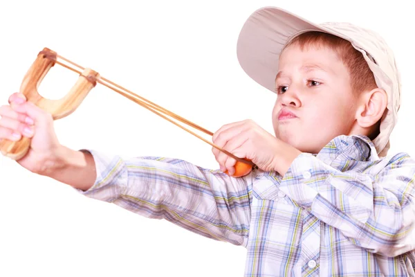 Junge schießt mit Schleuder auf Mandarine. — Stockfoto