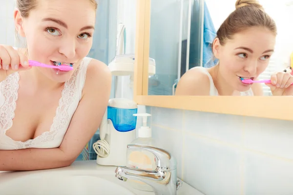 Dişlerini fırçalayan genç bir kadın — Stok fotoğraf