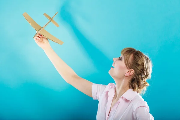 Vrouw denkt over vakantie houdt vliegtuig — Stockfoto