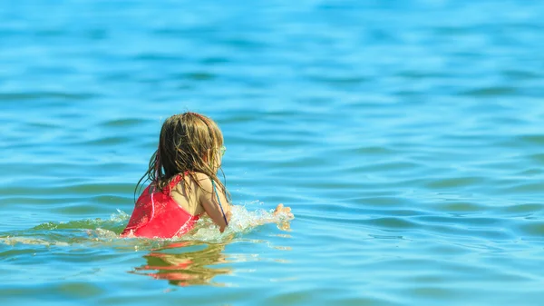 海の水で泳いでいる女の子の子供。楽しさ — ストック写真