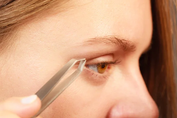 Woman plucking eyebrow — Stock Photo, Image