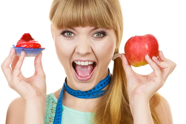 Femme qui choisit un fruit ou un gâteau faire un choix alimentaire — Photo