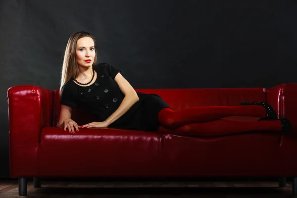 Fashion woman in red pantyhose on couch — Stock Photo, Image