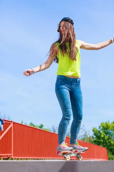 Dospívající dívka bruslař na koni skateboard na ulici. — Stock fotografie