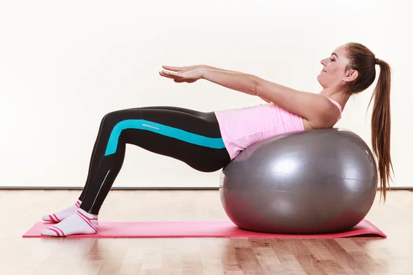 Mujer joven haciendo ejercicio en el gimnasio — Foto de Stock