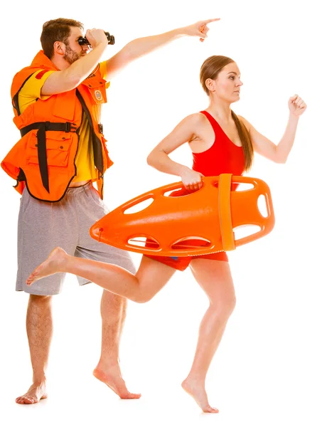 Lifeguards in life vest with rescue buoy running — Stock Photo, Image