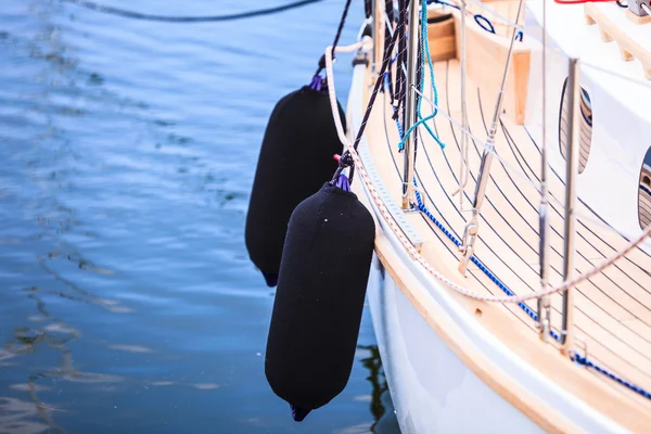 Sidan av skrovet segelbåt med svarta fendrar — Stockfoto