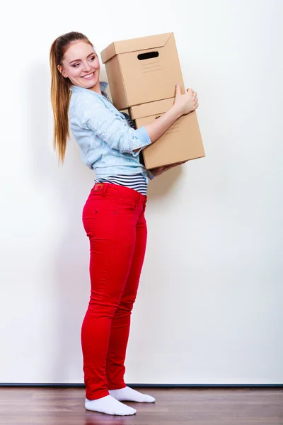 Happy woman moving into house carrying boxes. — Stock Photo, Image