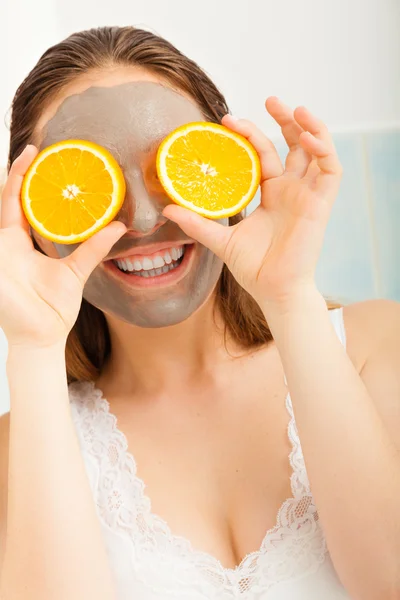 Mulher segurando fatias de frutas laranja — Fotografia de Stock