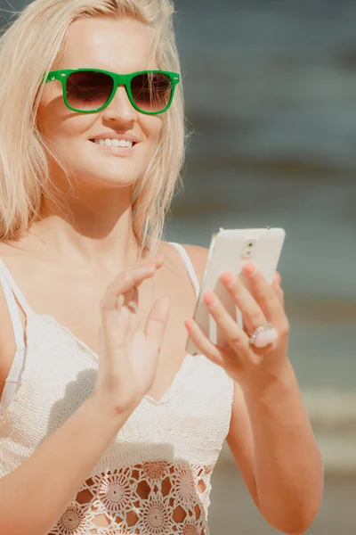 Flicka på stranden med telefon. — Stockfoto