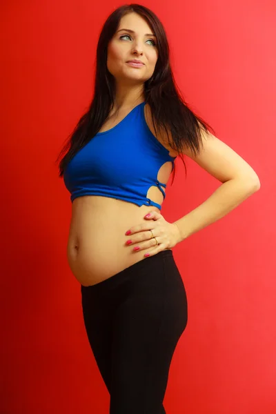 Cabello largo en forma de mujer embarazada en rojo — Foto de Stock