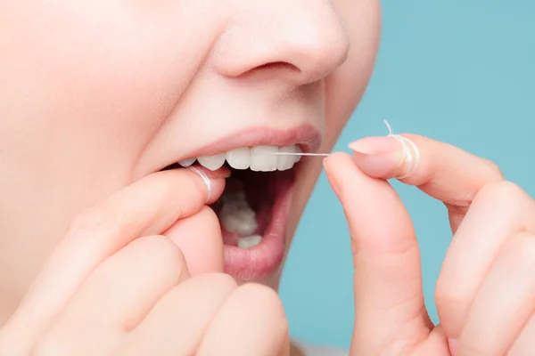 Mujer usando hilo dental —  Fotos de Stock