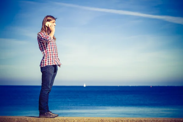 Man vid havet tar emot ett samtal på sin telefon — Stockfoto