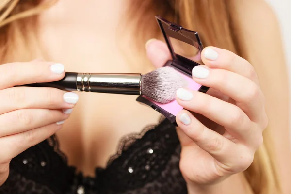 Mujer aplicando rouge con cepillo — Foto de Stock