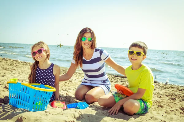 Család anya lánya fia szórakozás a strandon. — Stock Fotó