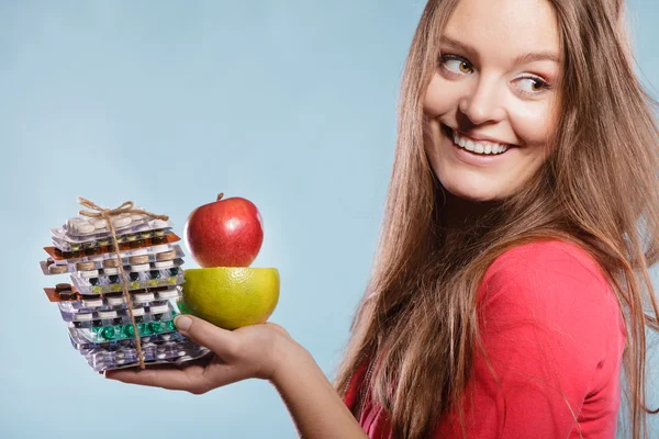 Mulher menina segurando comprimidos e frutas — Fotografia de Stock