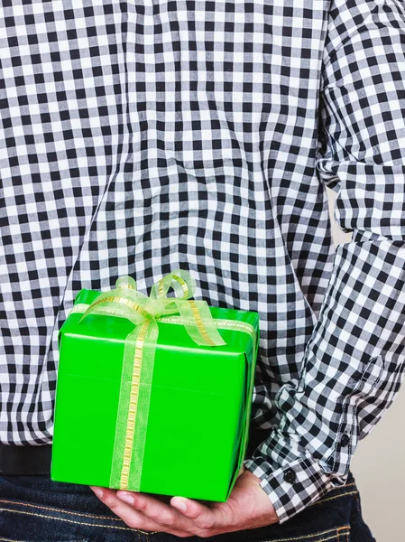 Man hiding gift box behind back. Birthday surprise Stock Image