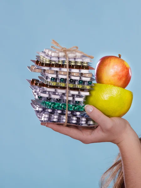 Mãos humanas segurando pílulas e frutas. Serviços de saúde — Fotografia de Stock