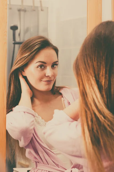 Woman taking care of her long hair in bathroom — Stock Photo, Image