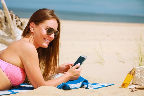 Mujer en la playa mensajes de texto en el teléfono inteligente . —  Fotos de Stock