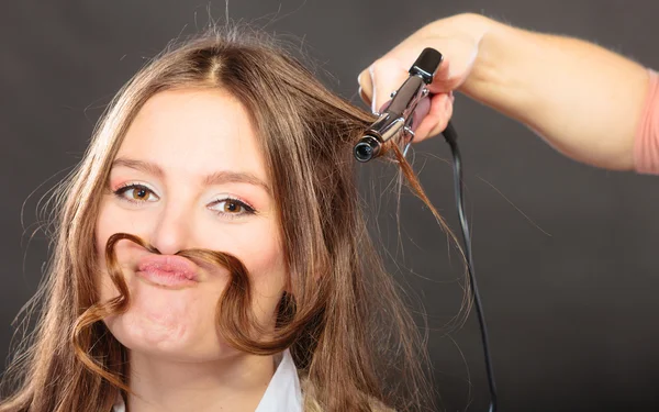 Estilista rizando el pelo para mujer joven. —  Fotos de Stock