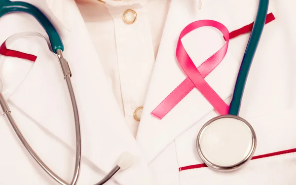 Nastro rosa con stetoscopio su uniforme medica . — Foto Stock